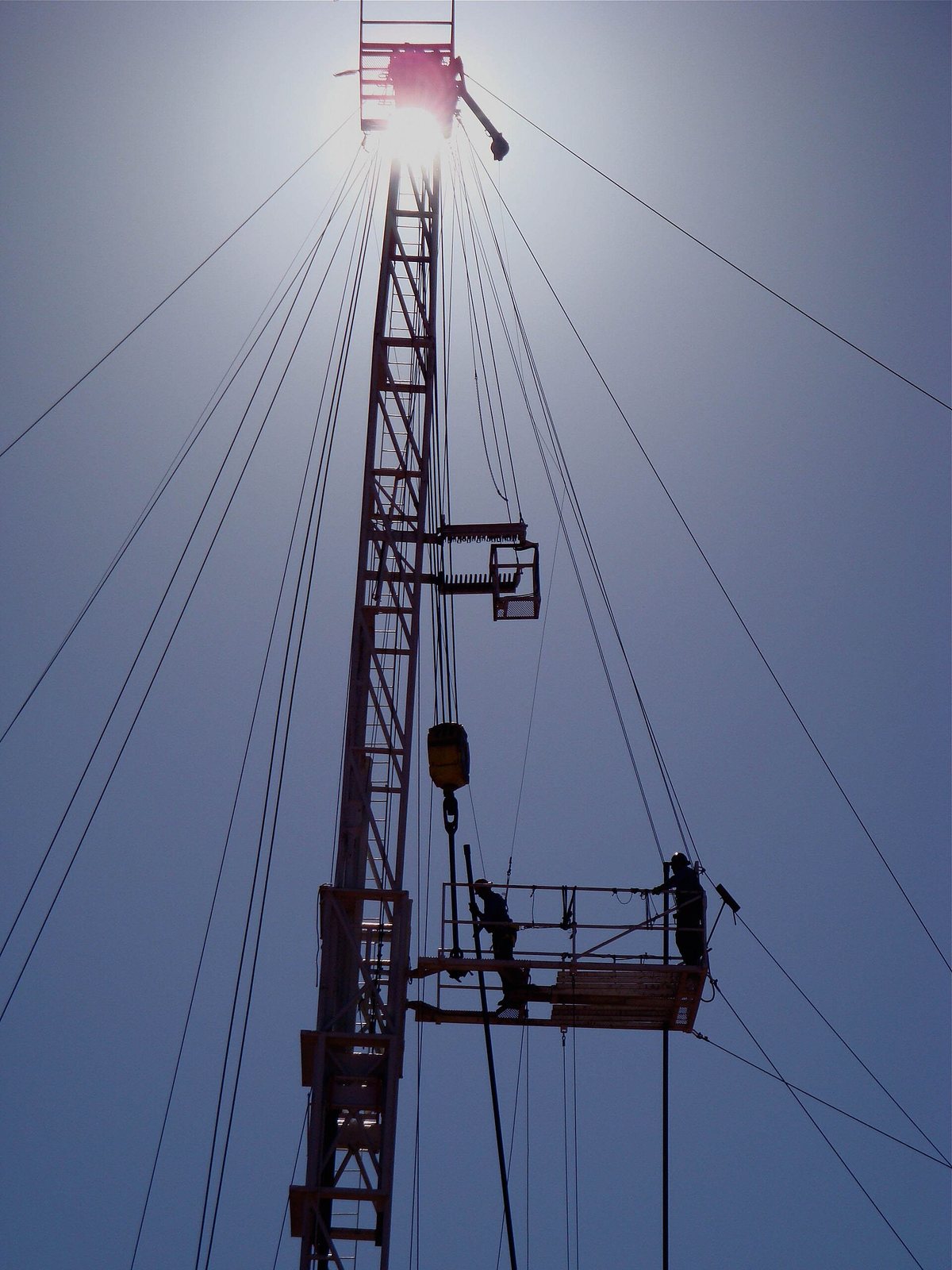 Two workers high on an oil drilling rig near Artesia.