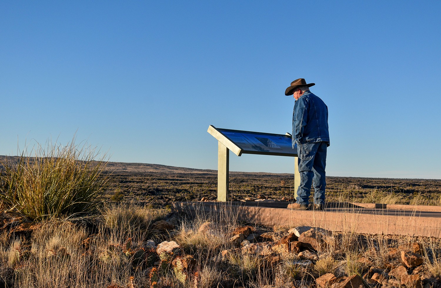 A visitor reads a new interpretive sign at Valley of Fires Recreation Area near Carrizozo.