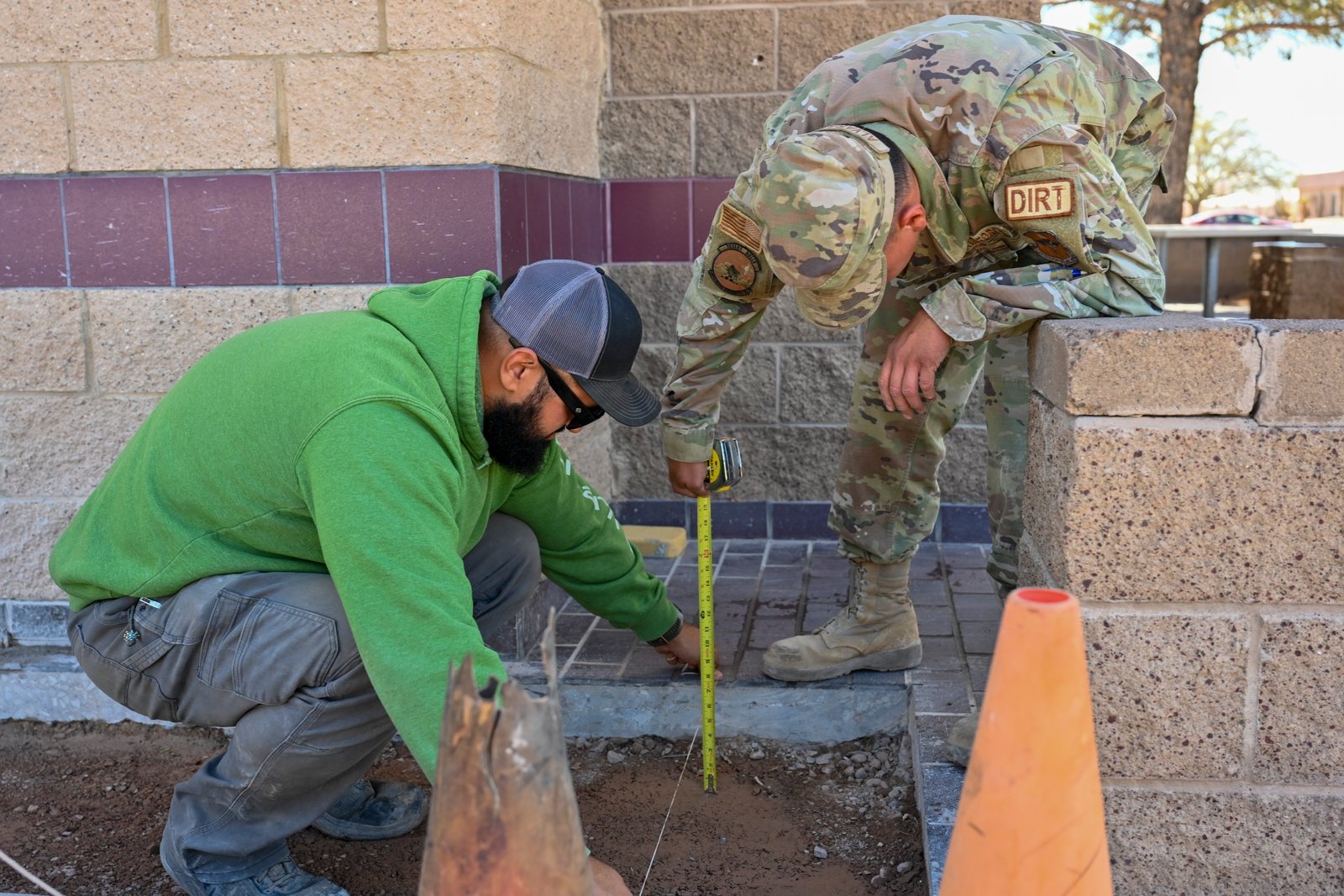 Civil engineering workers measure a sidewalk before a concrete repair at Holloman Air Force Base.