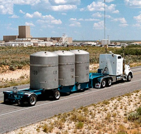 A truck carries industrial cargo along a highway.