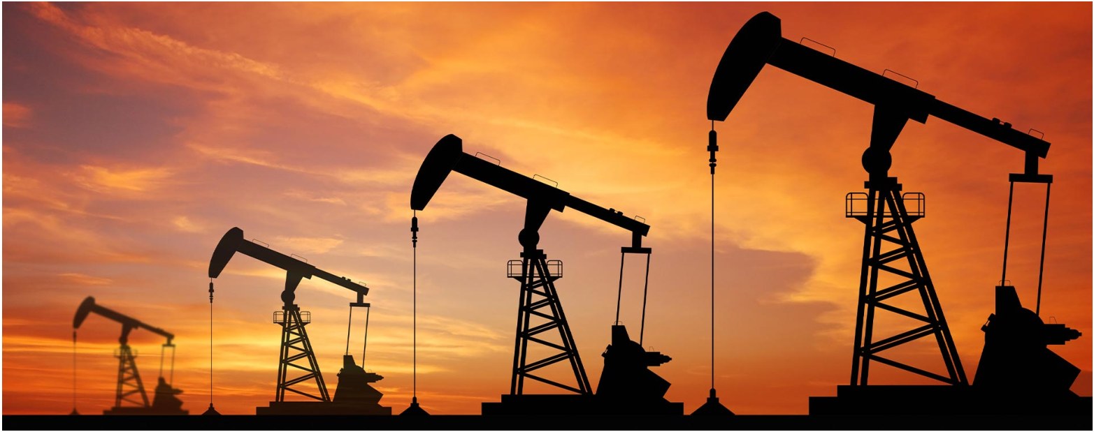 Oil pumpjacks silhouetted against a sunset.
