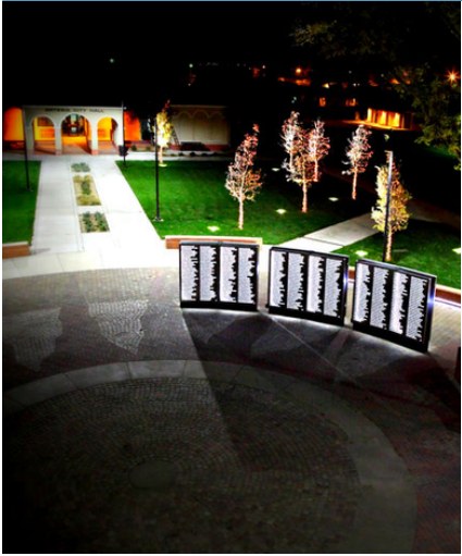 A community memorial and public courtyard at night.