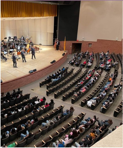 A live performance in a large auditorium.