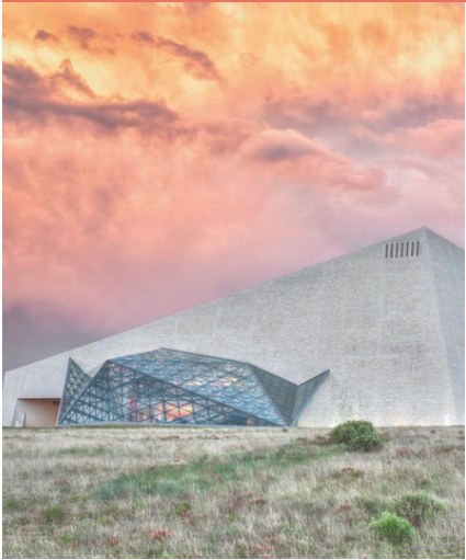 Contemporary cultural building beneath a pink evening sky.